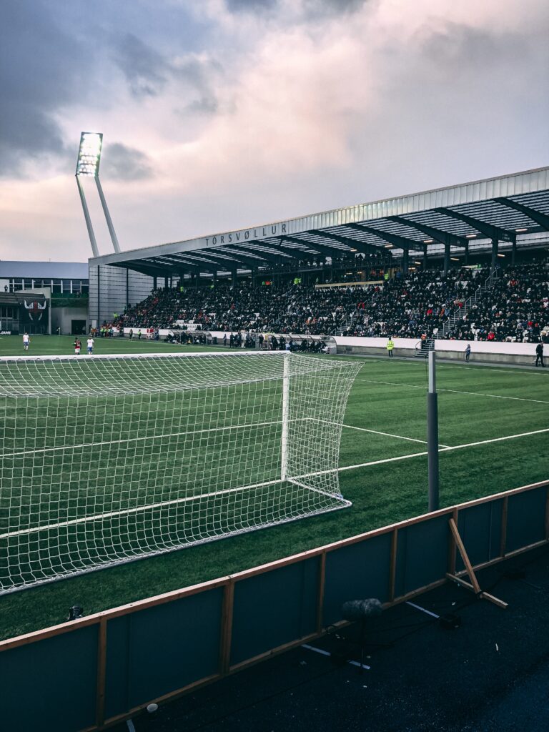 A vertical shot of crowded soccer stadium under cloudy sky